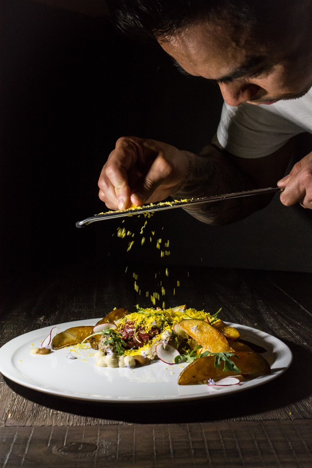 Chef garnishing a gourmet dish with precision and artistry