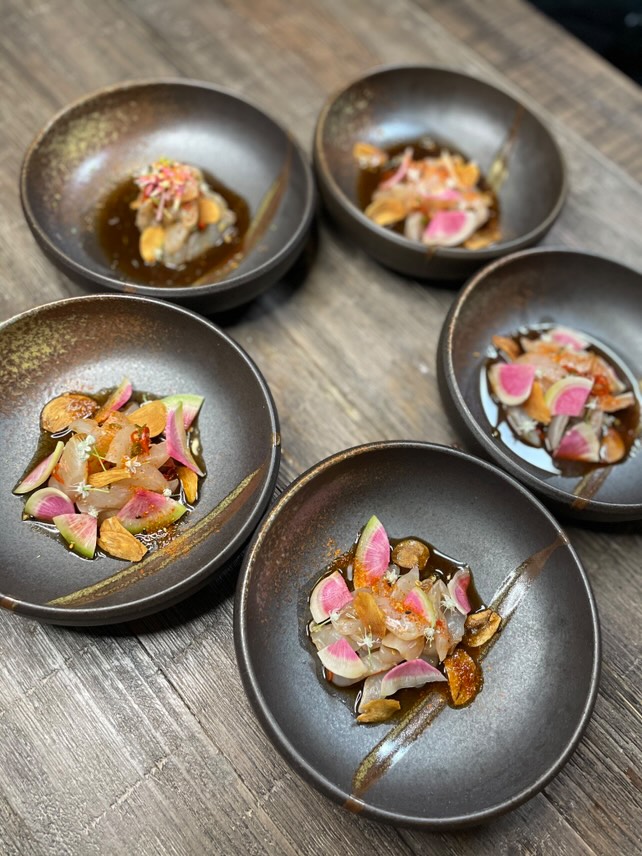 Elegant seafood appetizers with watermelon radish in ceramic bowls for corporate event catering